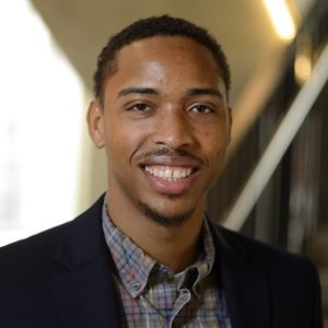 A headshot of Jeremy Brown wearing a black blazer