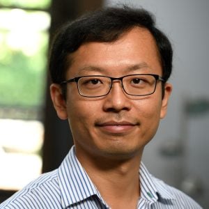 A headshot of Rui Ni wearing a blue striped shirt.